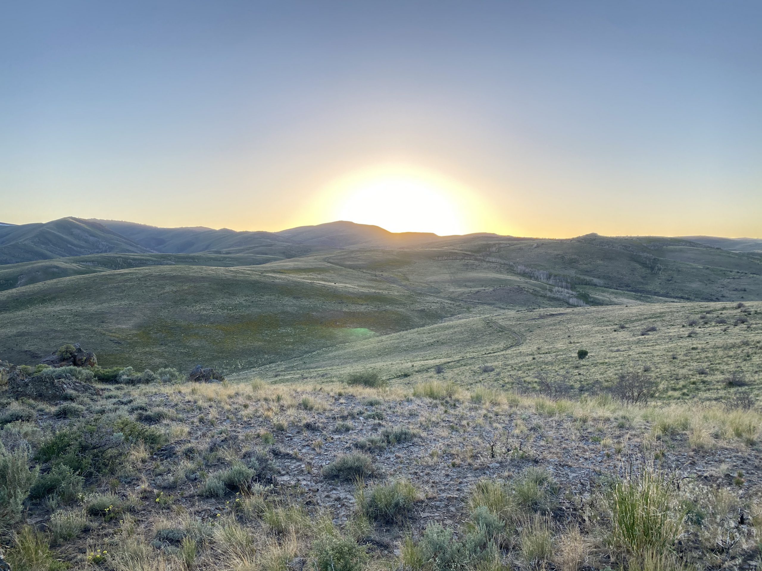 Picture of the sun setting behind mountains